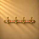 Moroccan brass rack with warm orange resin inlay and 4 hooks. Handmade wall-mounted coat and towel hooks. Each piece one of a kind.