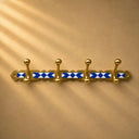 Moroccan handmade brass coat rack with blue-and-white resin inlay and 4 hooks. Wall-mounted entryway or bathroom décor. Each piece unique.