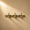 Handcrafted Moroccan brass coat rack with black-and-white resin diamond inlay and 3 hooks. Bold wall hooks for any room.