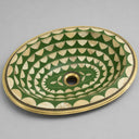 Decorative Brass sink with green and beige pattern on a gray background