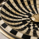 Close-up of a black Resin Bone Inaly and white checkered pattern with a gold accent.