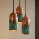 Handmade copper cylinder pendant light featuring an oxidized green patina finish and warm copper tones.