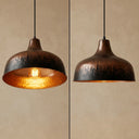 Close-up view of the hand-hammered brass texture and antique brass finish on a handmade pendant light.