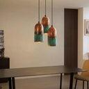 Close-up of a handmade oxidized copper pendant lamp showcasing the hammered copper texture and natural green verdigris patina.