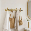Handcrafted 4-hook brass wall rack featuring decorative resin inlay. Perfect for coats, towels, robes, bags, and entryway organization in luxury interiors.