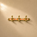 Moroccan brass rack with warm orange resin inlay and 3 hooks. Handmade wall-mounted coat and towel hooks. Each piece one of a kind.