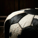 Close-up of a patterned fabric with black and beige colors on a dark background