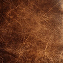A close-up of dark brown textured leather with visible grain and fine scratches.