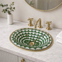 Bathroom sink with green and white patterned basin and gold fixtures.
